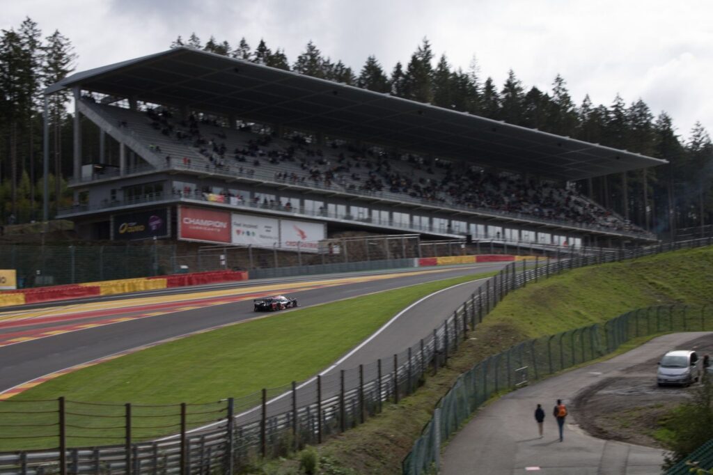 Exciting Formula One race at Circuit de Spa-Francorchamps, Belgium with packed stands and racing cars.