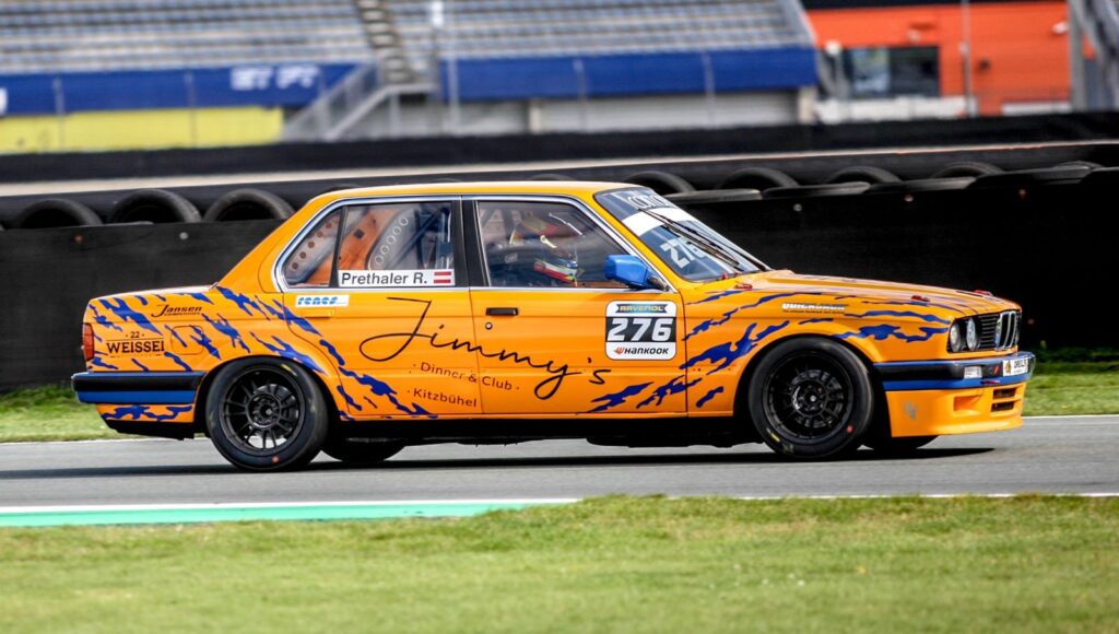 Vibrant vintage race car speeding on a track, showcasing dynamic motion.