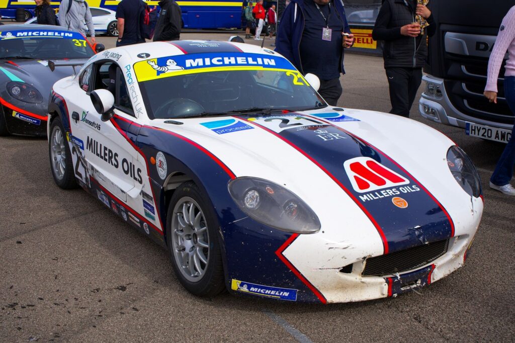Close-up of race cars with Millers Oils branding at Silverstone track.
