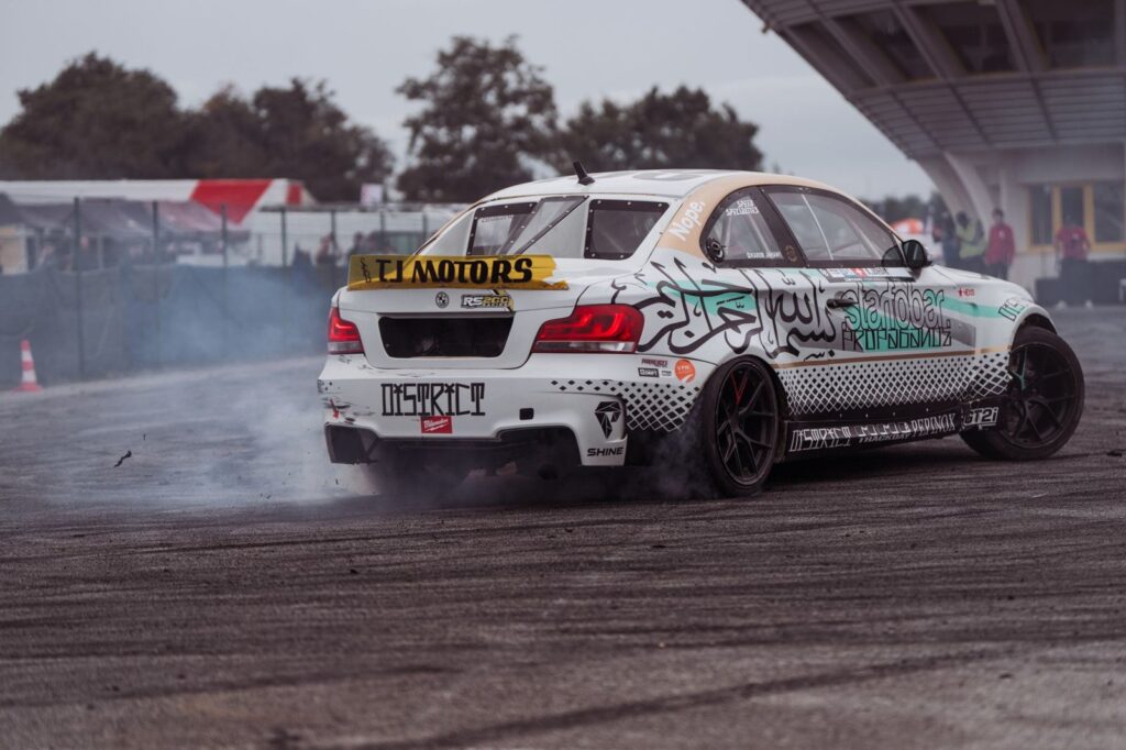 Car performing drift maneuver at motorsport event in France. Action-packed scene.